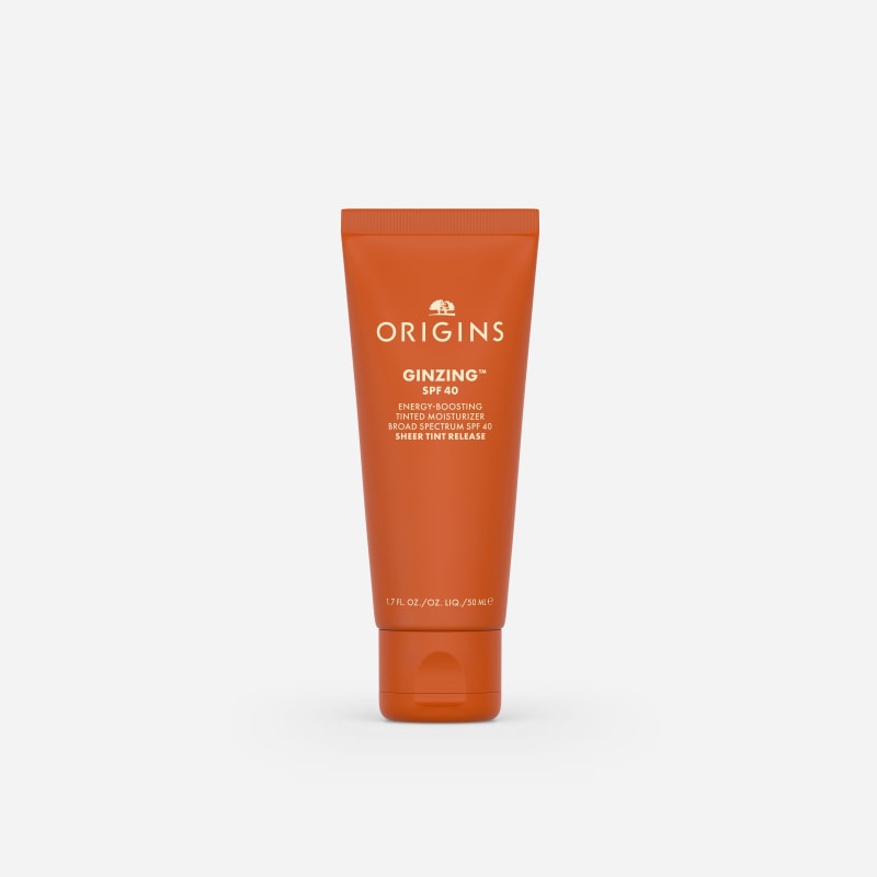 Origins GinZing SPF 40 Energy-Boosting Tinted Moisturiser in a 50ml orange tube on a grey background.