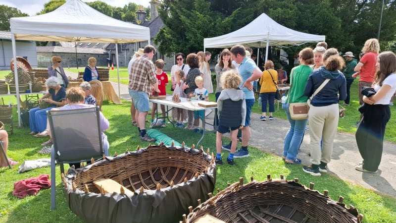 Families and children taking part in traditional willow basket weaving demonstrations at Turlough Park outdoors.