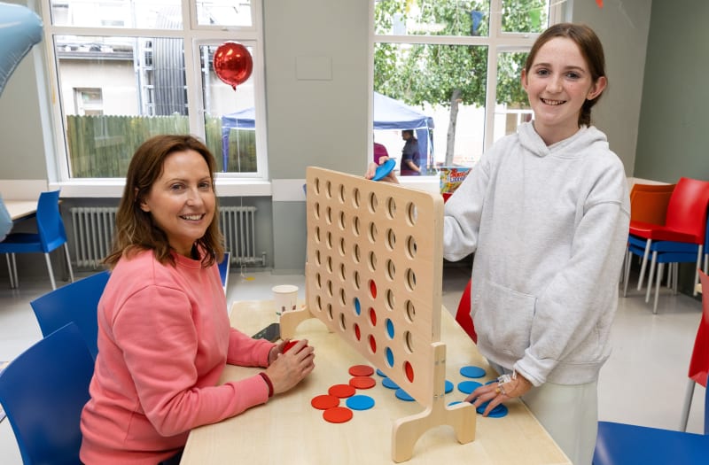 Juliet and her Mum Gina playing a large wooden Connect Four game at CHI Crumlin International Play Day.