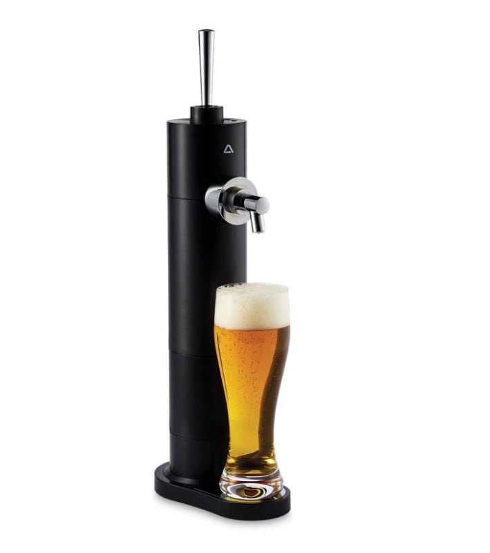 Matte black home beer dispenser tower with chrome tap and a full pint glass of beer with foam head.