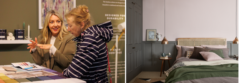 Two women reviewing Heritage paint colour swatches at a display stand, beside a styled bedroom with grey-green panelled walls.