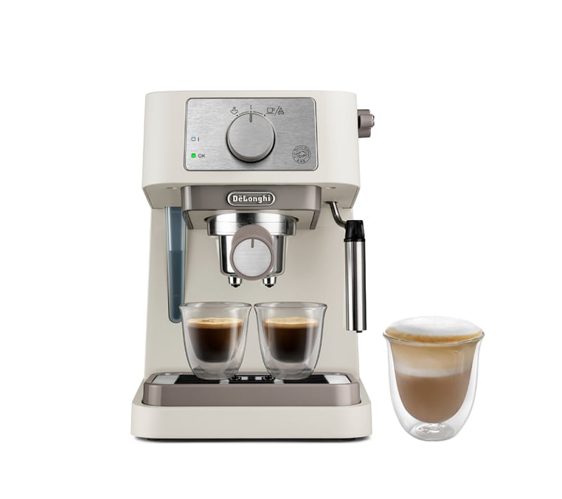 De'Longhi Stilosa espresso machine in cream with two espresso glasses and a frothy cappuccino glass alongside.