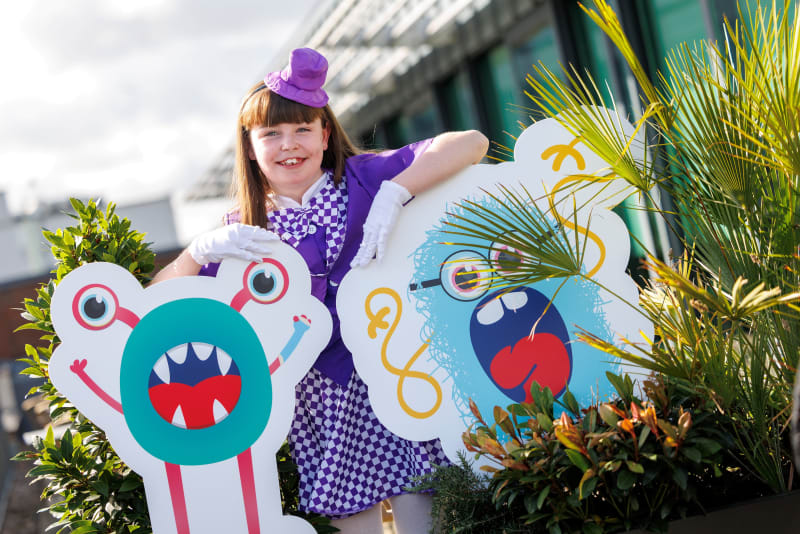 Alice, an 11-year-old CHI patient from Cavan, poses with cartoon monster cutouts at the Children's Health Foundation Trick or Treat 2026 launch.