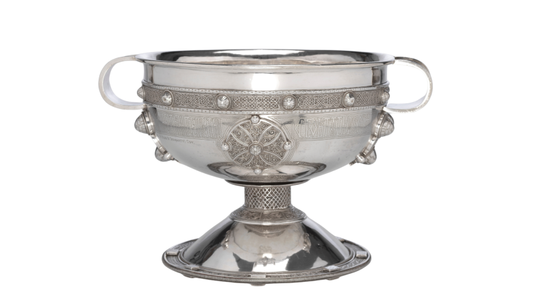 Ornate 19th century silver chalice with Celtic knotwork band, decorative medallions, and pedestal base, Turlough Park.