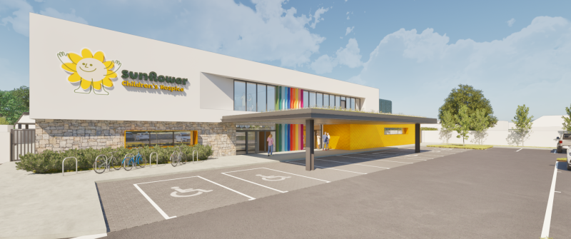 Architectural rendering of the new Sunflower Children's Hospice building with yellow entrance canopy and rainbow panels.