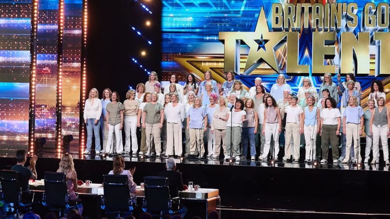 Sea of Change choir performing on stage at Britain's Got Talent, large group of women in neutral tones.